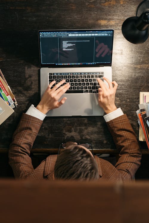 A person typing on their laptop