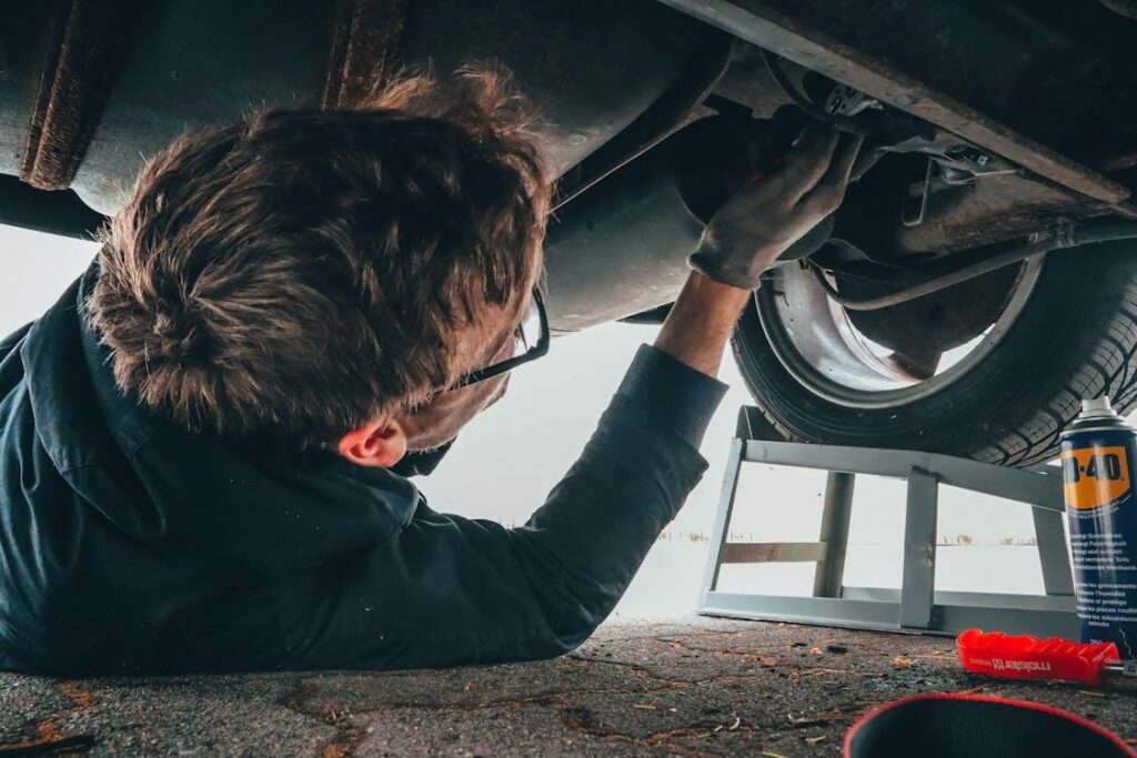 A mechanic working on the exhaust of a car