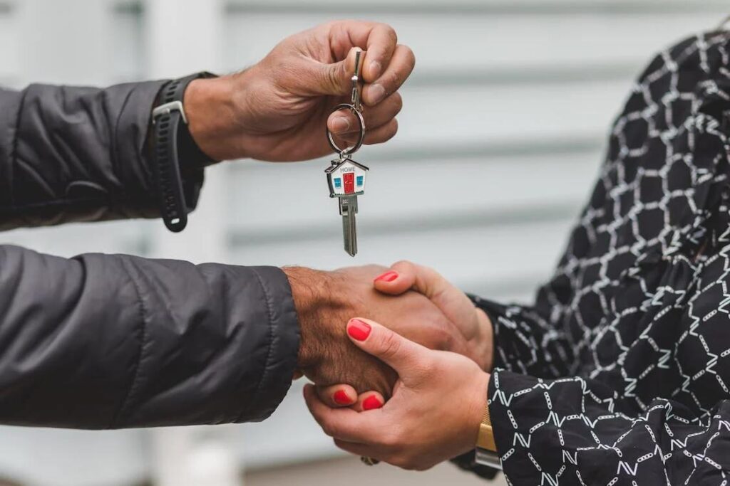 Real estate agent handing house key to a woman